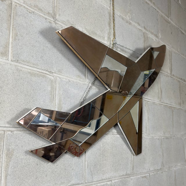 A dramatic and monumental wall mirror shaped like a jet plane, an iconic piece of modern art with a strong visual impact,...