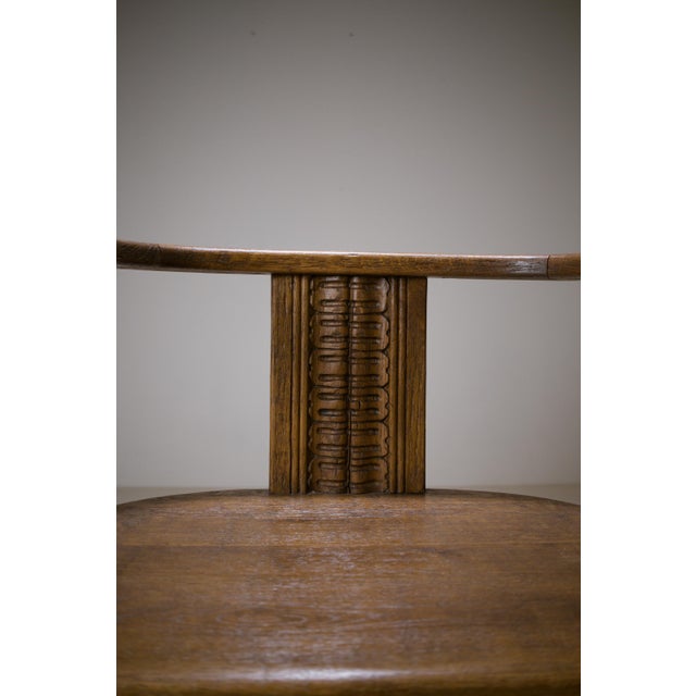 Distinctive swivel armchair in solid carved oak, likely dating from the early 20th century. The chair features a wooden...