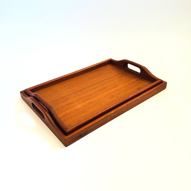A set of 2 vintage rectangular teak nesting trays. Beautiful grain to the wood, nice large size for a variety of needs....