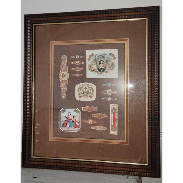 Set of Two picture frames with collection of Cuban cigar memorabilia. Cuban Advertising for cigars in sticker and cloth...
