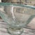 Features a distinct light green or "marine green" color and a textured, bubbly finish. Supported by a solid, clear glass...