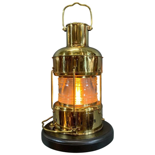 Meticulously polished and lacquered ship’s anchor lantern with Fresnel glass lens, protective bars, carry handles, etc....