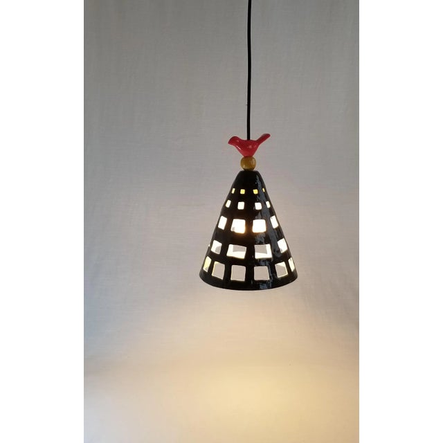 One of a kind handmade ceramic pendant light, hangs from a black, 15' plug-in cord. The original cone shape has been...