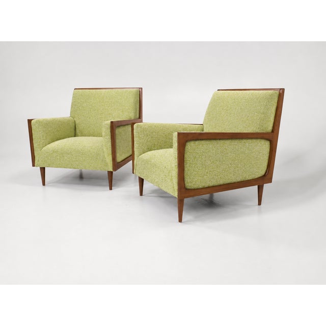 Modern mid-century style lounge chairs. The pair of chairs is newly upholstered and refinished. The chairs are done in a...