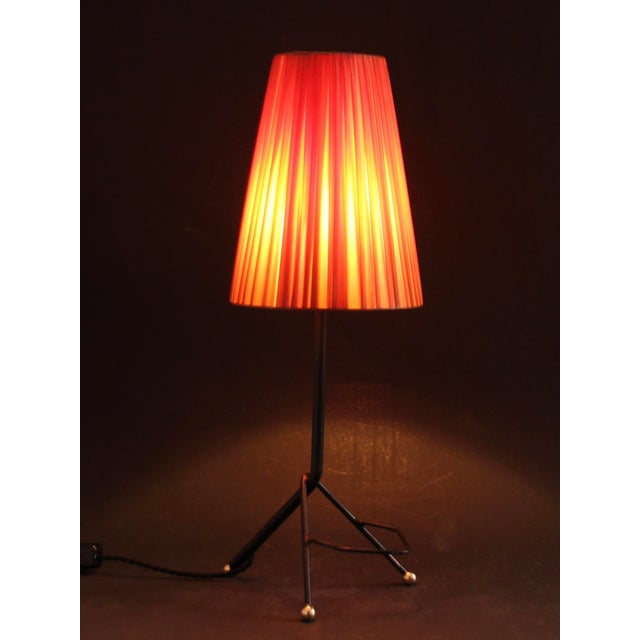 This 1950s rockabilly-style table lamp features a shade covered with red plastic ribbons, creating a very pleasant light....