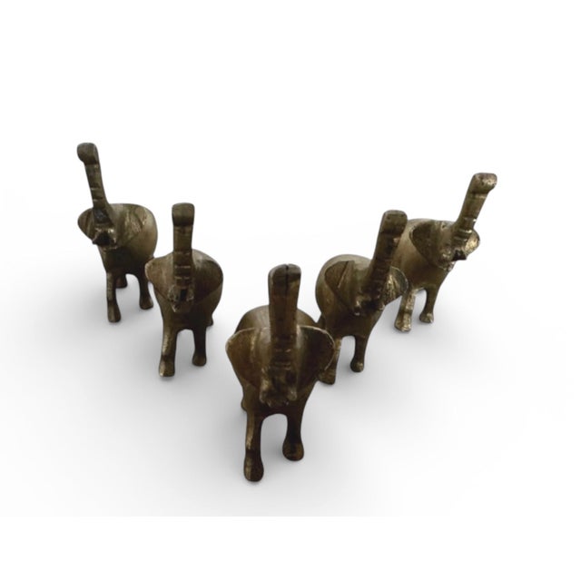 Each Elephant, Approximate: 2” W x 2 1/4”H x 3/4”D Presenting a captivating tableau of five miniature brass elephants,...