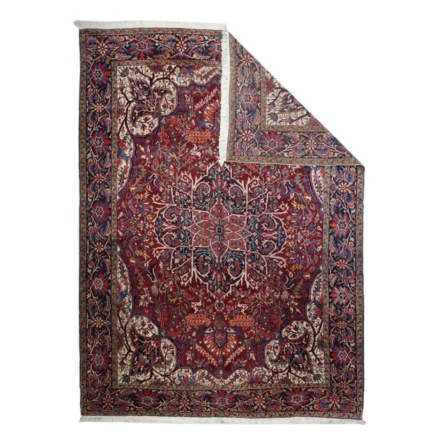 This all naturally dyed roomsize shows an unusual segmentally concave red field centred by a navy medallion with outline...