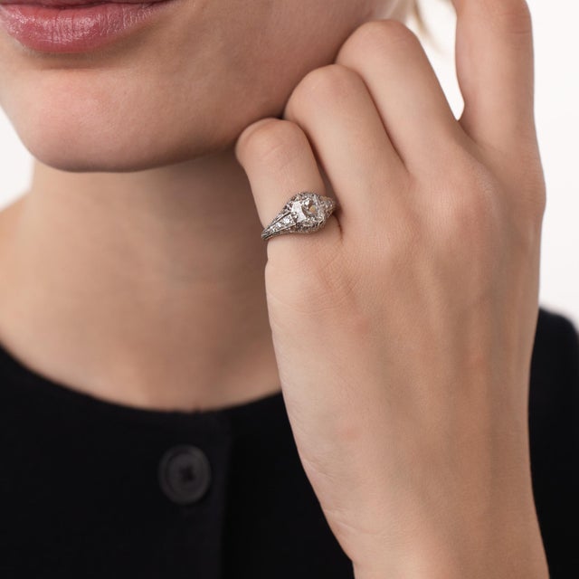 This beautiful Art Deco diamond engagement ring is a refined 1920’s design, centered by a GIA-certified cushion brilliant...