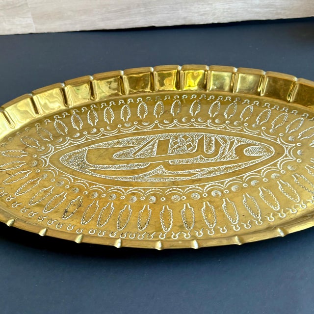 This beautiful vintage Islamic calligraphy brass tray features exquisite hand-engraved details and a rich golden patina....