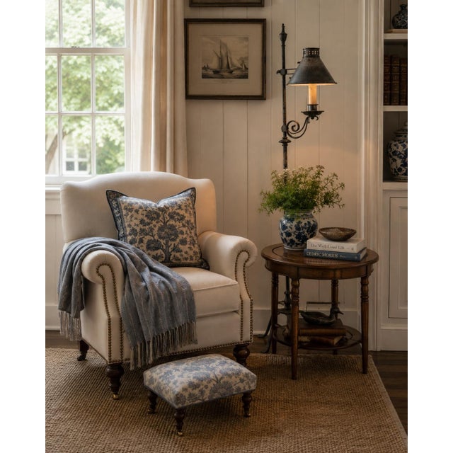 A handsome early 20th century forged iron floor lamp with a tall, slender standard, four-leg base, scrolling candle arm,...