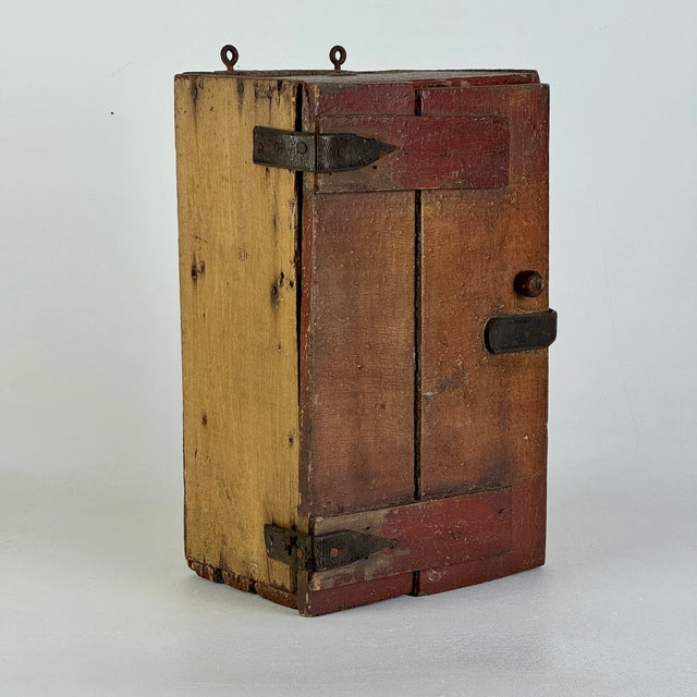 A marvelous piece of Americana. An early 19th Century villager made wooden cupboard, with an original red paint and...