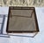 Small side table with a smoked bronze glass top on a square steel tube frame with a "bronze-copper" finish. Two are...