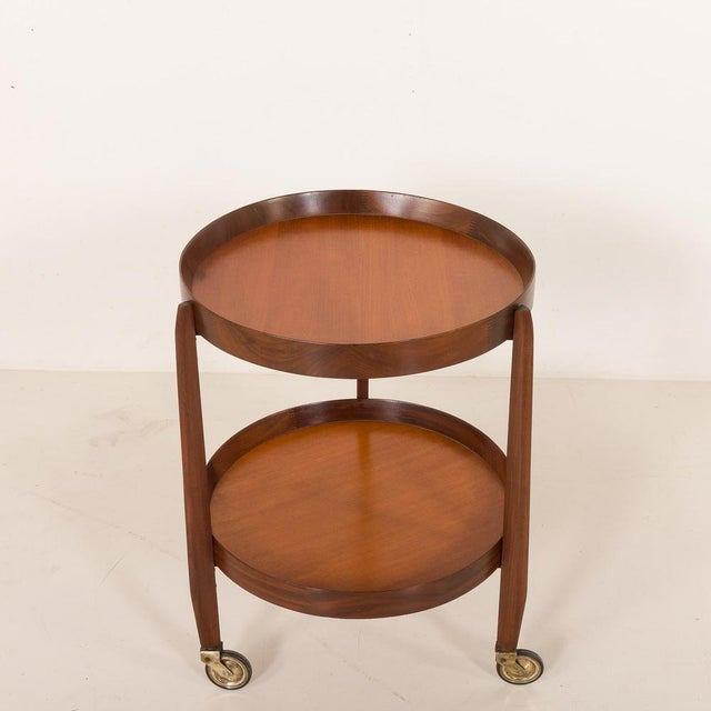 An elegant Italian mid-century teak round bar cart comes from the 1960s. The trolley features two trays surrounded by...