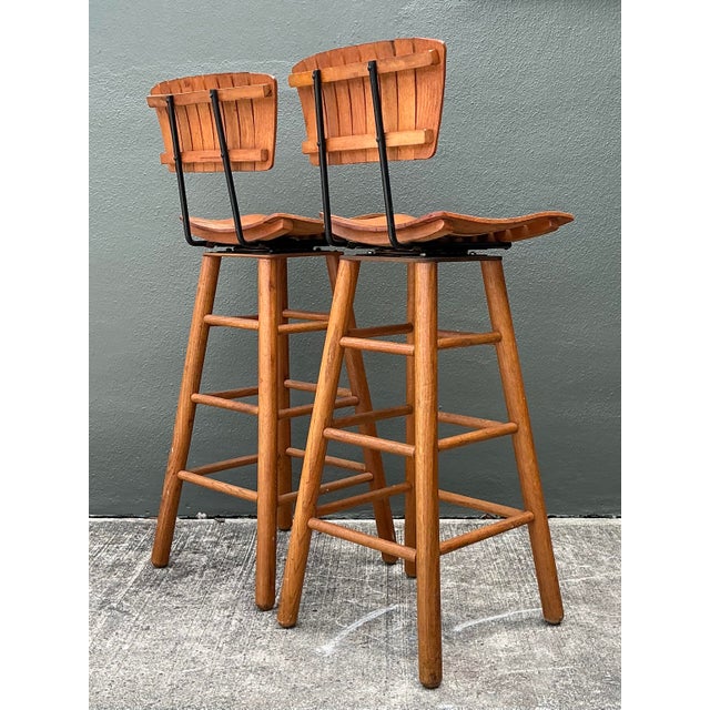 This handsome pair of swivel bar stools captures the iconic Mid-Century Modern aesthetic, designed in the distinct manner...