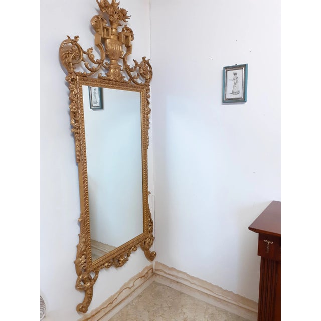 Baroque style mirror of high Florentine craftsmanship in carved wood and decorated in gold leaf. Unique piece of high...