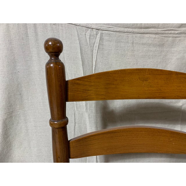 A pair of antique shaker cherry wood ladder back chairs with original rush caned seats, Ca. 19th c. A handsome pair of...