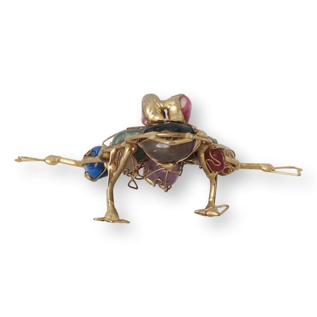 Hand-carved frog sculpture made from polished semi-precious stone with natural striations of green, brown, and cream....
