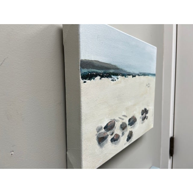 A desolate beach littered with rocks in the foreground