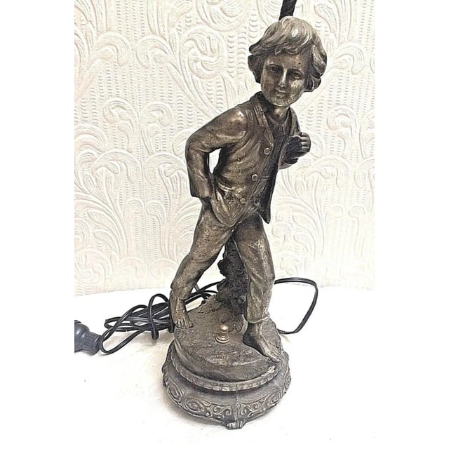 This is an antique silver plated spelter figural boy lamp that measures 18” tall, with the figure itself measuring 14". It...