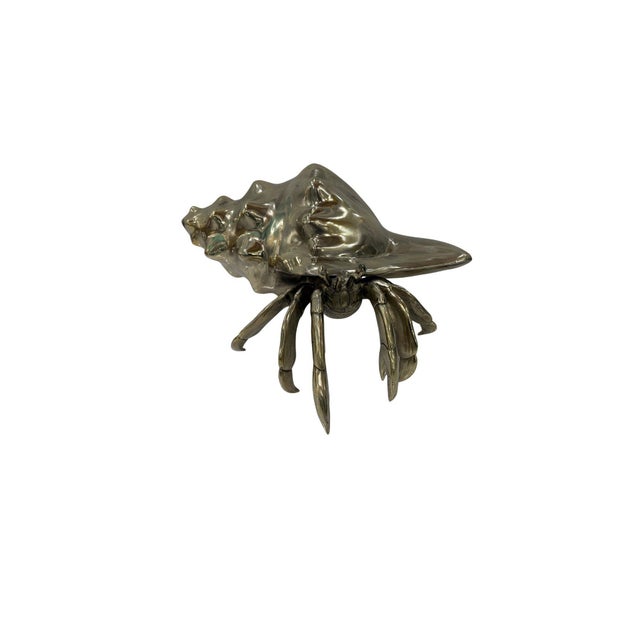 A distinctive cast bronze hermit crab sculpture, merging organic coastal inspiration with sculptural artistry. The piece...