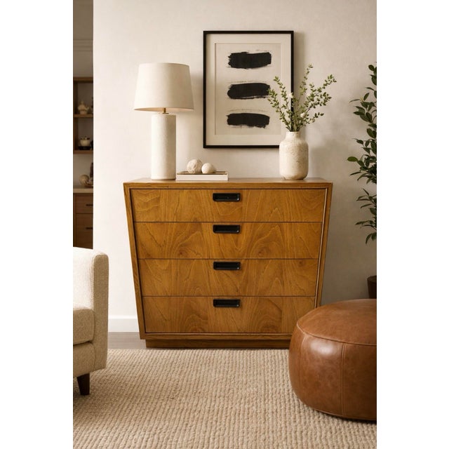 Classic American mid-century modern chest of drawers featuring a clean rectilinear form, warm oak veneer, and understated...