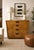 Classic American mid-century modern chest of drawers featuring a clean rectilinear form, warm oak veneer, and understated...