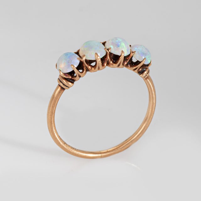 Sweet antique Victorian era ring (circa 1900), crafted in 14 karat yellow gold. Cabochon cut opals measure 4mm. The opals...