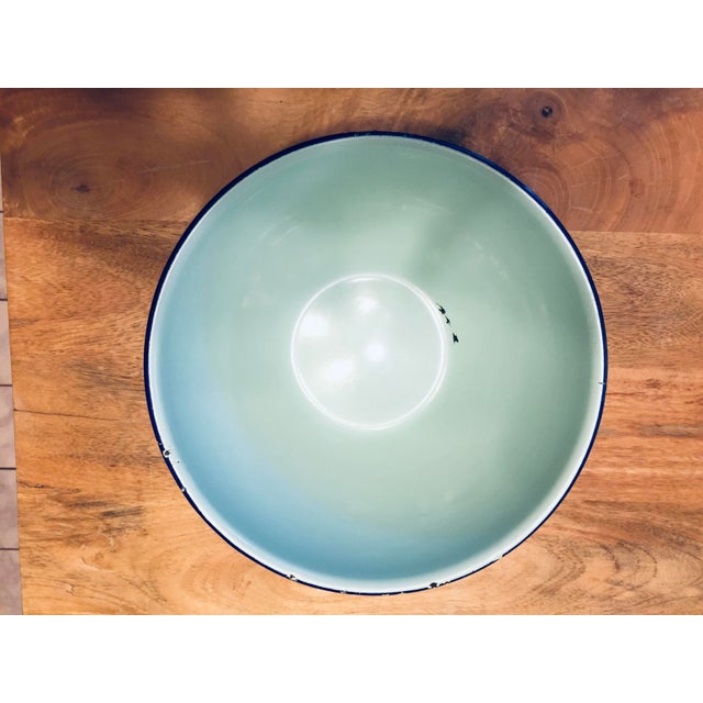 A vintage, 9" enameled metal bowl in an unusual pale teal with a navy band around the top edge. The height is 3 5/8". This...