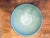 A vintage, 9" enameled metal bowl in an unusual pale teal with a navy band around the top edge. The height is 3 5/8". This...