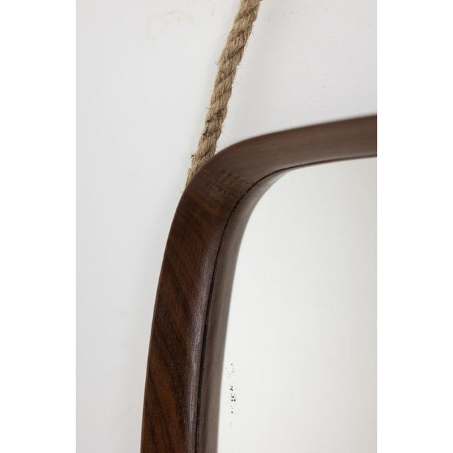 Mirror in a teak frame with a shadow box design. Rectangular shape softened by slightly curved sides. Wide rope hanging...