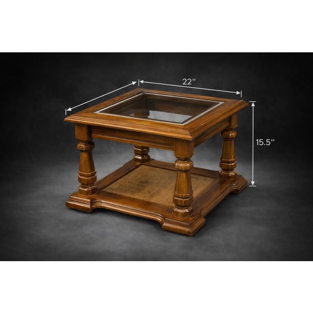 A handsome vintage square accent table featuring a beveled glass inset top, turned column supports, and a woven cane lower...