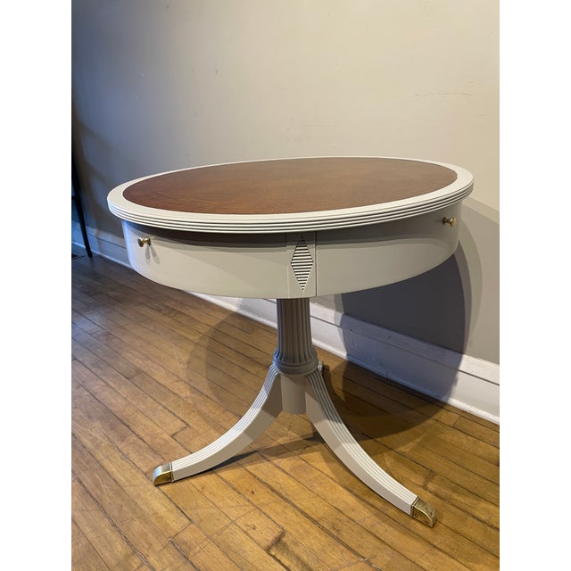 This Duncan Phufe Styled tooled leather top drum table has a pedestal leg and brass hardware. It has beed professionally...