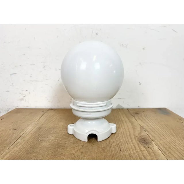 Vintage industrial ceiling light made in former Czechoslovakia during the 1950s. It features a white porcelain ceiling...