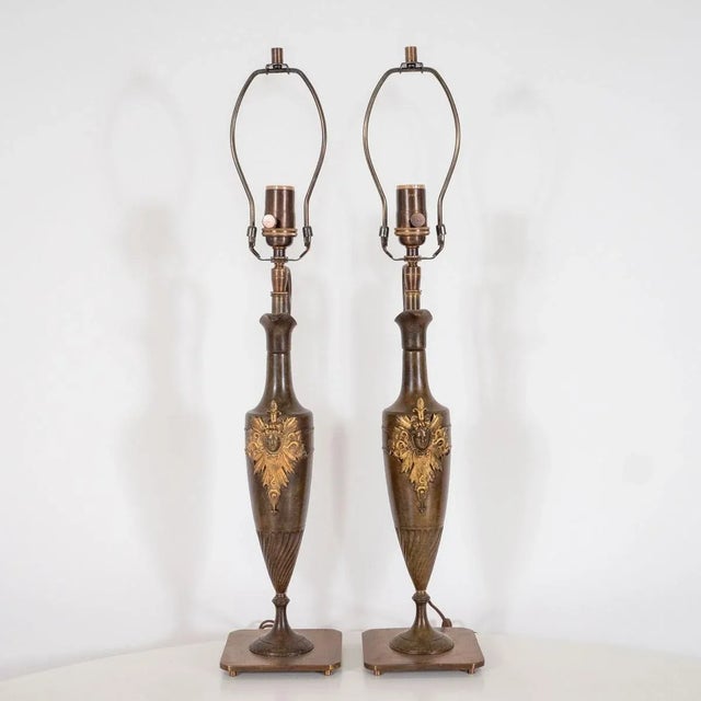 Pair of bronze amphora shaped tabled lamps with intricate gilt metal crests Origin: United States Circa: 1950s Dimensions:...