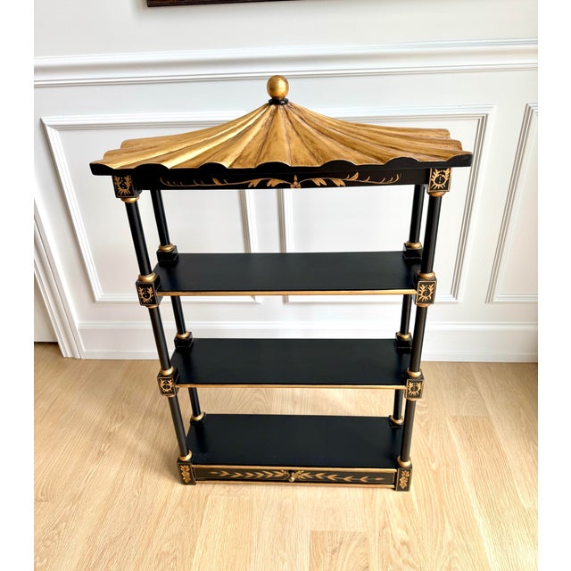 A timeless Chinoiserie pagoda-form wall étagère by Union National Furniture. Finished in matte black with hand-painted...
