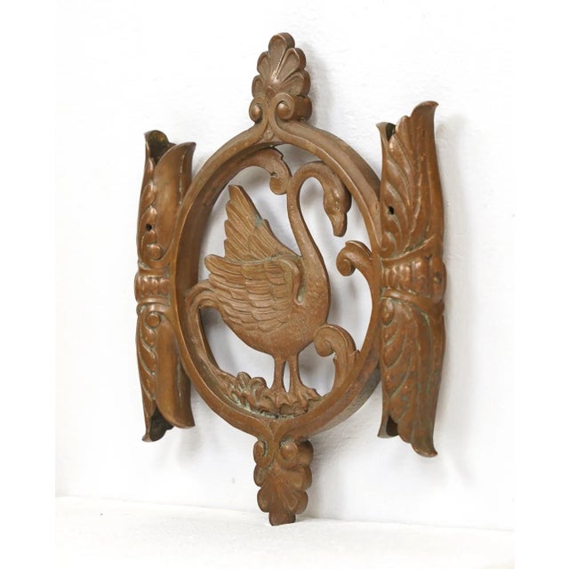 Reclaimed bronze piece with ornate details featuring a swan in the center. The sides are shaped to hold poles with...
