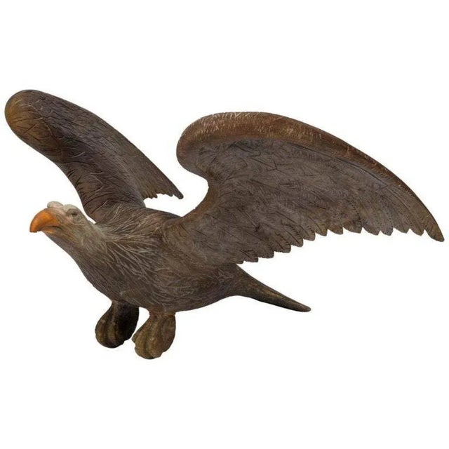 Presented is a spread wing eagle, most likely from the late 19th to early 20th century. This carved pine eagle is poised...