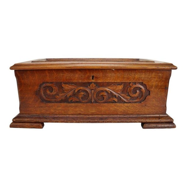 This antique Jackpot cylinder music box from the 19th century features a finely carved oak case with intricate foliate...