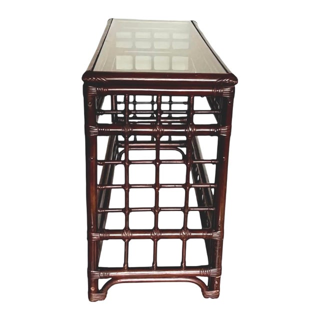 Attributed to Brown Jordan, this elegant faux bamboo console table dates to the 1970s and reflects the refined Palm Beach...