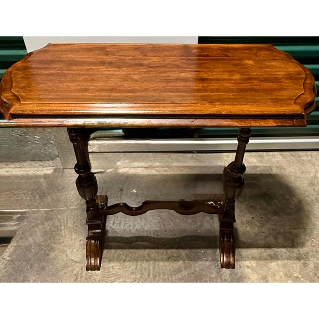 This elegant wooden table features classic 19th century design elements, characterized by a scalloped-edge rectangle top...