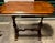 This elegant wooden table features classic 19th century design elements, characterized by a scalloped-edge rectangle top...