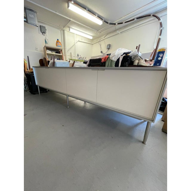 This is a long white modern media cabinet, console or media cabinet from B&B Italia. It is wood and another material I’m...