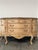 A stunning vintage French Provincial–style marble-top credenza featuring an elegant curved silhouette, ornate carved...