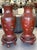 A pair of monumental red lacquered Chinese palace vases on stands. These are crafted out of wood and paper mache. There...