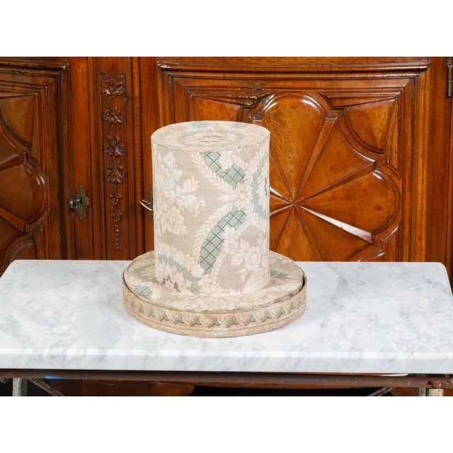 An English Victorian period paper hat box from the 19th century, with floral motifs and book pages. Created in England...