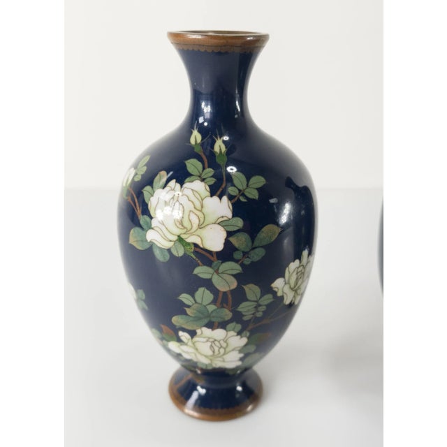 We are selling this nice pair of Japanese cloisonne enamel vases. These vases have blue grounds with white rose floral...