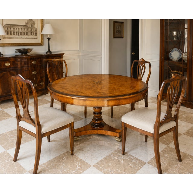 A beautifully crafted round dining or center table by Theodore Alexander, featuring an exquisite burl walnut veneer top...