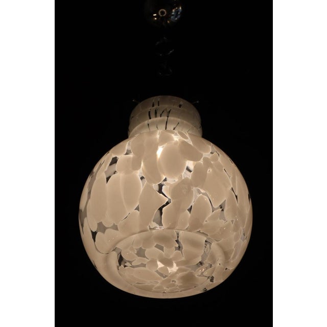 Vintage Italian hanging lamp made from Murano glass in the 70s. Transparent and white globe with chrome-plated metal...
