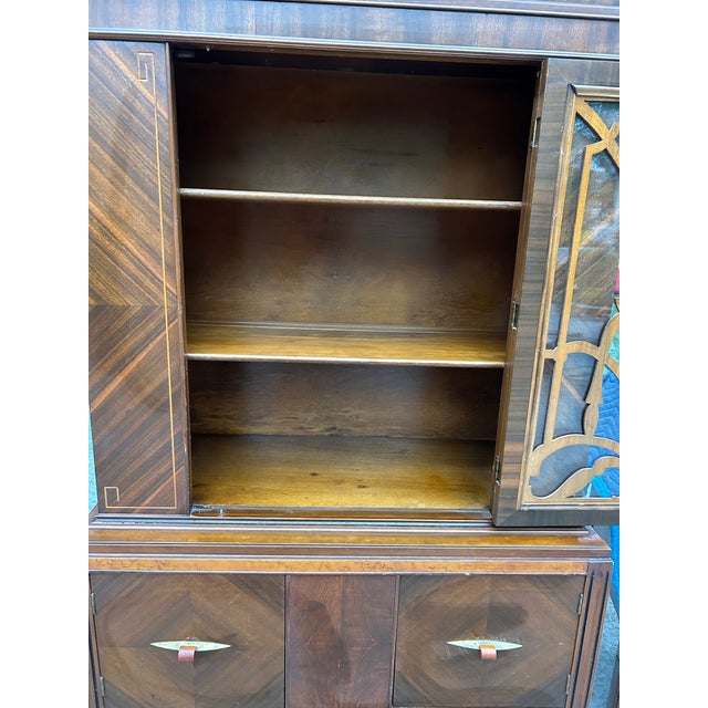 An exquisite, highly stylized American Art Deco waterfall china cabinet dating from the late 1930s to early 1940s. The...
