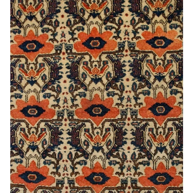 A wonderful early 20th Century Persian Senneh rug with all-over red poppies and leaf pattern, surrounded by multiple...